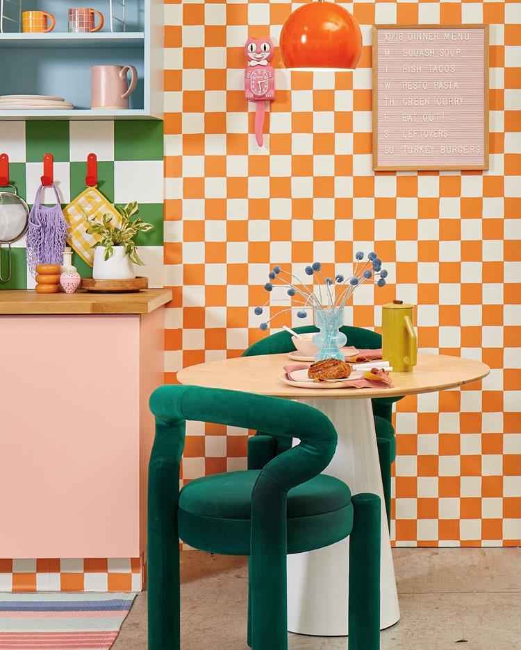 mesa pequena de madeira em cozinha com parede quadriculada laranja