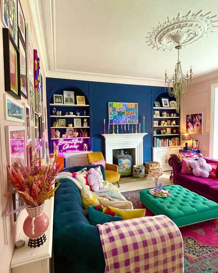sala de estar de decoração maximalista, tons de rosa, verde e azul em destaque, muitos quadros e objetos no ambiente
