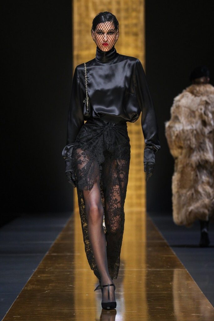 Modelo utilizando look total dark, com boina preta de véu rendado no desfile da Dolce & Gabbana.
