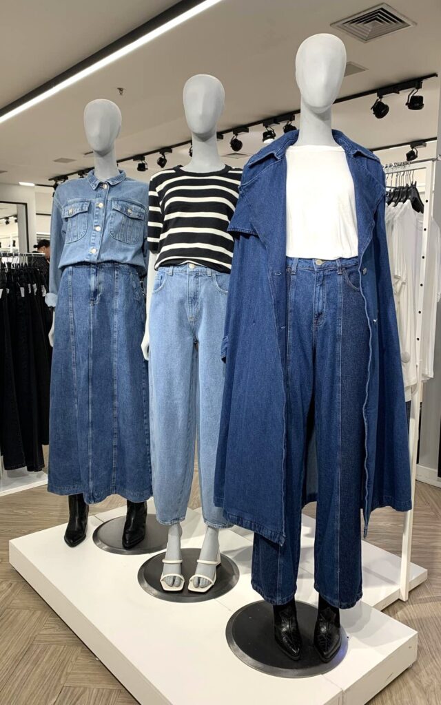 Três manequins totalmente vestidos de jeans, e com calça jeans de diferentes modelos e lavagens, na C&A do Iguatemi, em São Paulo.