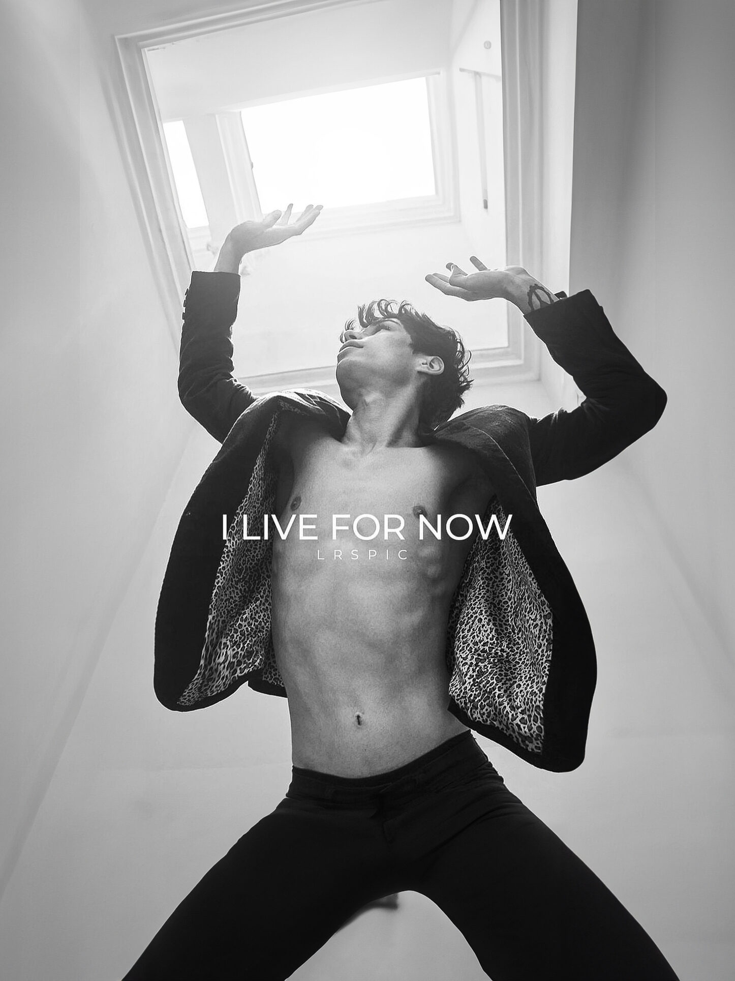Foto preto e branca de modeo sem camisa, com um casaco por cima, com as escritas "I LIVE FOR NOW LARS PIC"