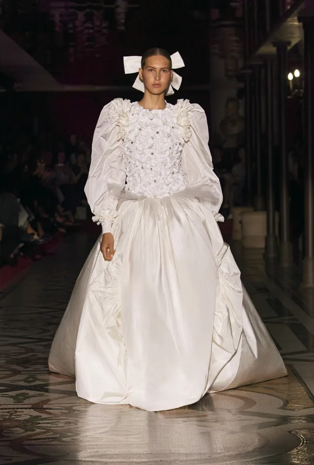 Modelo de Chanel vestindo um vestido de noiva da coleção, com bordados e muito volume.