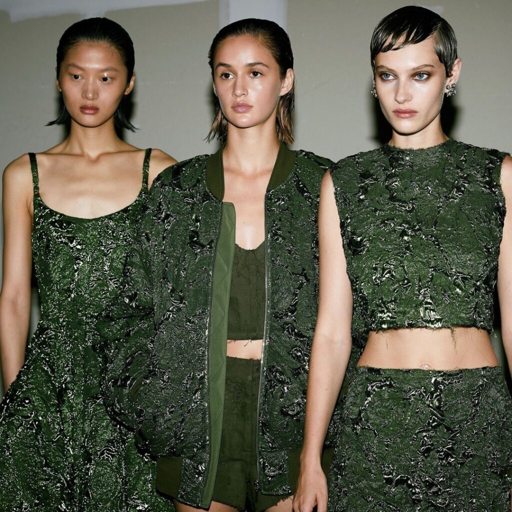 Três modelos trajando peças verde musgo pertencentes a coleção primavera/verão 2024 de Jason Wu.