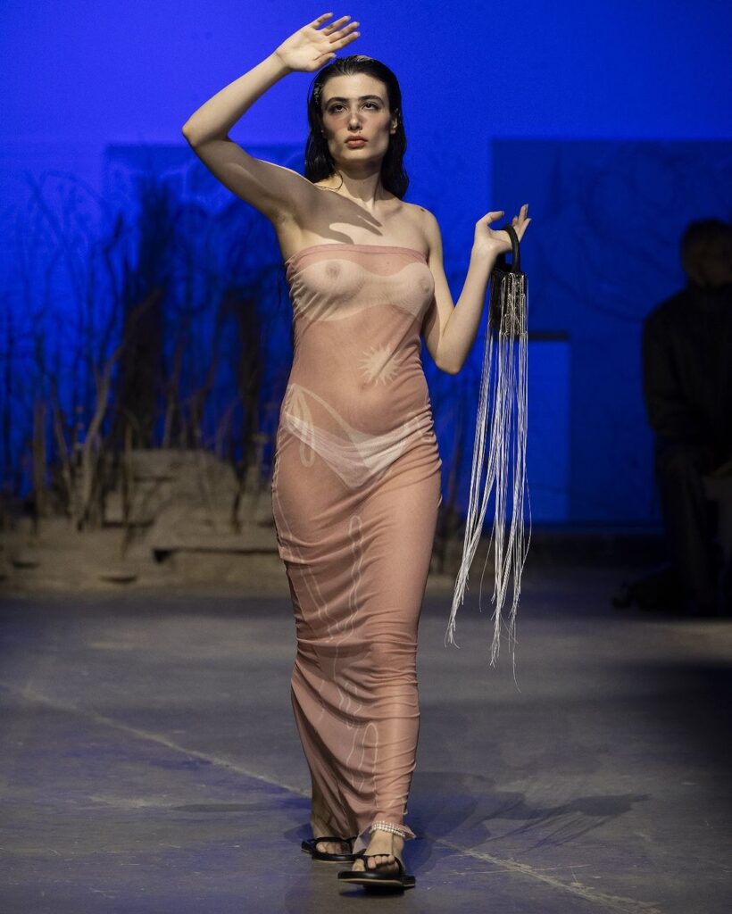 Modelo com vestido bronze transparente em desfile de primavera da Di Petsa.