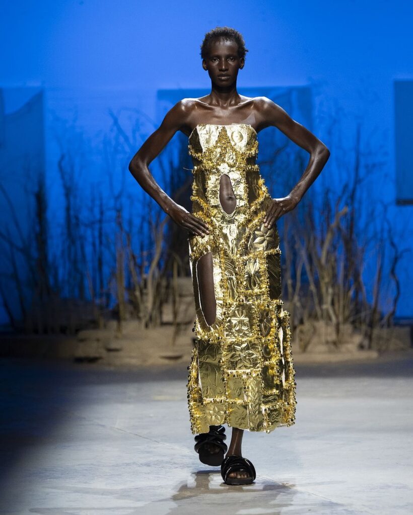 Modelo com vestido em folhado dourado em desfile de primavera da Di Petsa. 