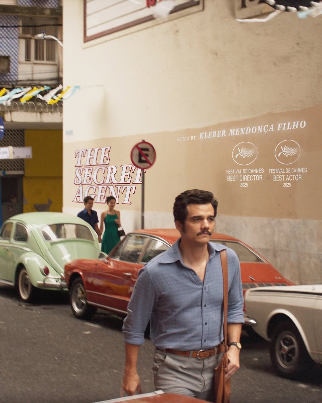 homem branco de camisa azul, bigode preto