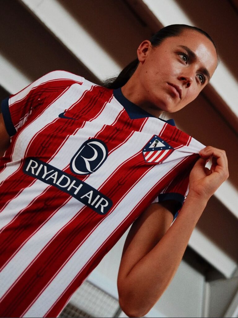 Camisas de futebol: Camisa 2026/27 com o Tridente de Netuno, símbolo tradicional das comemorações do Atlético de Madrid. Detalhe que busca despertar conexão com o público fã deste time.